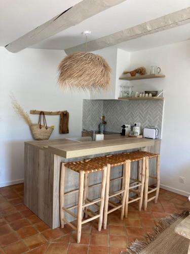 a kitchen with a counter and stools in a room at Lodge - Le Clos Devançon in Gréoux-les-Bains
