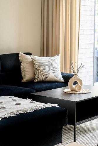 a living room with a blue couch and a coffee table at Pirties Spa namas in Molėtai