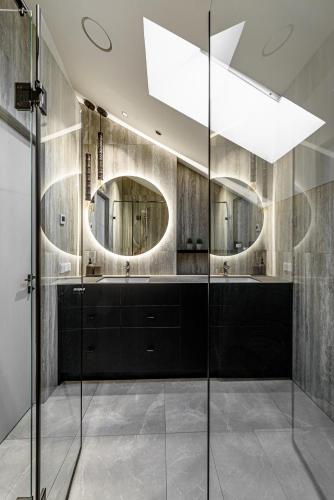 a bathroom with two sinks and two mirrors at Pirties Spa namas in Molėtai