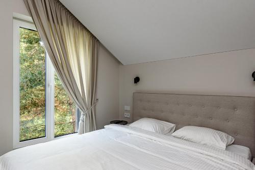 a bedroom with a large bed and a window at Pirties Spa namas in Molėtai