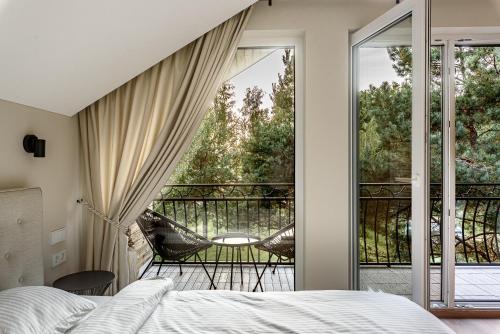 a bedroom with a bed and a balcony at Pirties Spa namas in Molėtai