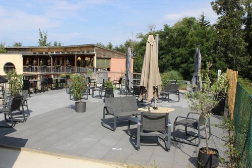 eine Terrasse mit Stühlen und Sonnenschirmen vor einer Bar in der Unterkunft Camping les Acacias in Altkirch