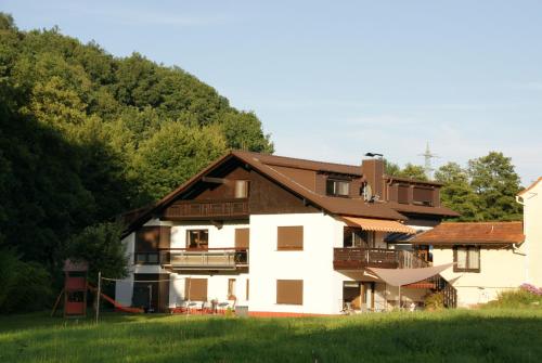 ein weißes Haus mit braunem Dach in der Unterkunft Ferienwohnung Siefert in Mossautal