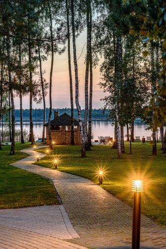 a walkway in a park with lights in the grass at Pirties Spa namas in Molėtai