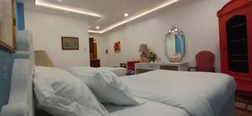 a bedroom with two beds and a mirror at Residencia Orlina in Dumaguete