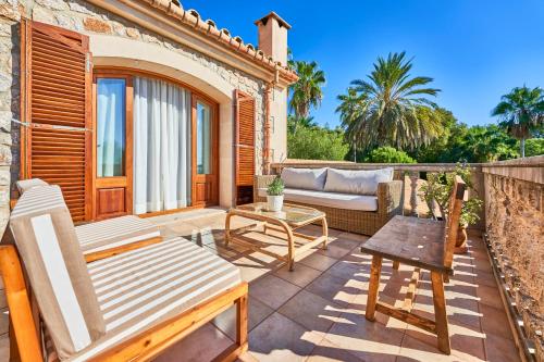 a patio with a couch and a table and chairs at Quiet Villa in Buger with amazing pool, paddle court and nice garden in Búger
