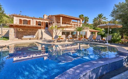 a large swimming pool in front of a house at Quiet Villa in Buger with amazing pool, paddle court and nice garden in Búger