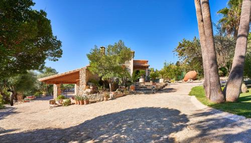 a resort with palm trees and a building at Quiet Villa in Buger with amazing pool, paddle court and nice garden in Búger