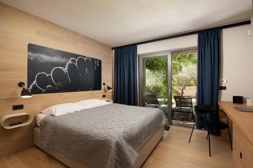 1 dormitorio con cama, escritorio y ventana en Casa Arbor Blanco, en Fažana