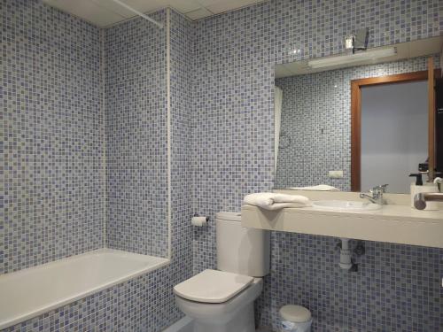 Baño de azulejos azules con aseo y lavamanos en Ap4Us B1 - Apartment for us - Sightseeing & Beach At The Best Price, en Badalona