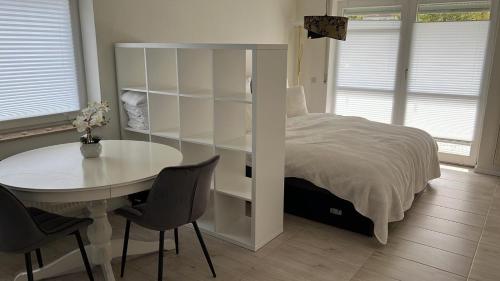 een slaapkamer met een bed en een tafel en stoelen bij Luxliv Apartements in Balingen