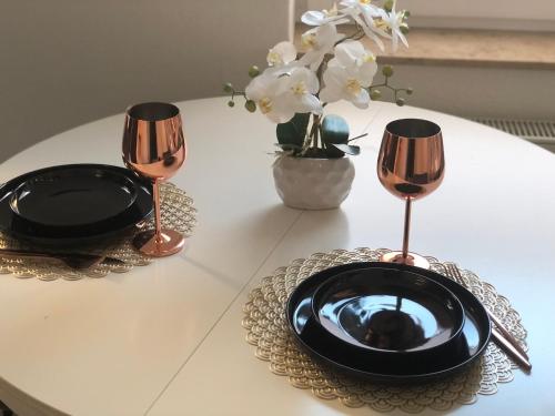 una mesa con un plato negro y dos copas de vino en Luxliv Apartements, en Balingen