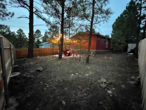 a yard with trees and a fence and a house at Cozy Mountain Town Farmhouse with Air Conditioning in Mountainaire