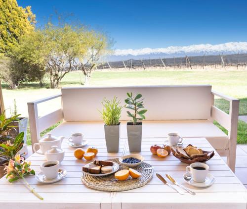 een witte tafel met daarop een dienblad met eten bij Casa Oseleta de Bodega Masi in Tupungato