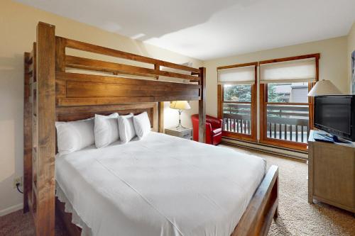a bedroom with a large bed and a flat screen tv at Lodge at Steamboat A203 in Steamboat Springs