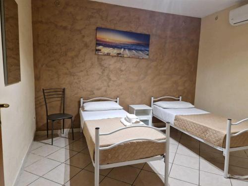 Zimmer mit 2 Betten und Wandgemälde in der Unterkunft La Domus Pompei Casa vacanza in Pompei