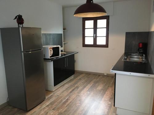 a kitchen with a refrigerator and a sink at La marine D'opale in Ambleteuse