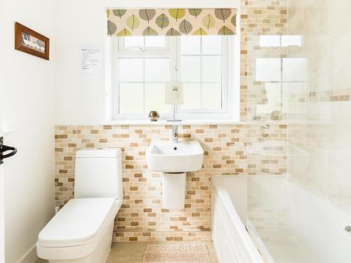 a bathroom with a toilet and a sink and a tub at Pass the Keys Traditional Comfy 2 Bed in Alderminster in Stratford-upon-Avon