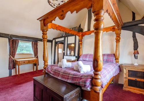 a bedroom with a four poster bed and a piano at No.36 Debenham in Debenham