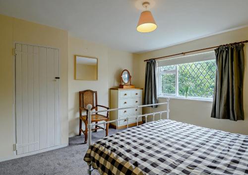 una camera con un letto e una sedia e una finestra di Black Tiles a Dennington