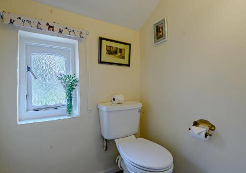 bagno con servizi igienici e finestra. di Black Tiles a Dennington