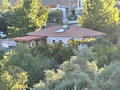 a white house with a red roof and trees at Beautiful 3 Bedr House in Arakapas with fireplace in Arakapas