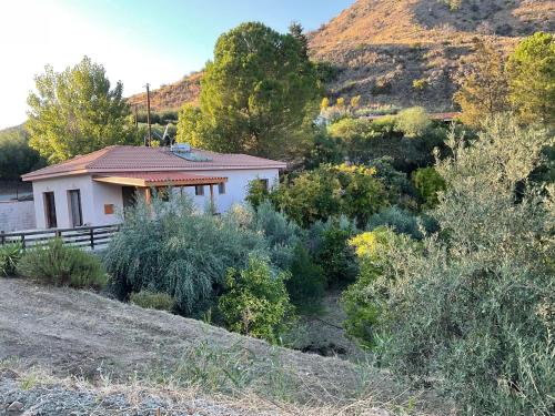 a small white house in the middle of a mountain at Beautiful 3 Bedr House in Arakapas with fireplace in Arakapas