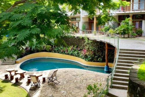 una piscina con una escalera junto a un edificio en Modern Studio/Apt overlooking Pool/Ocean view, en San Juan del Sur