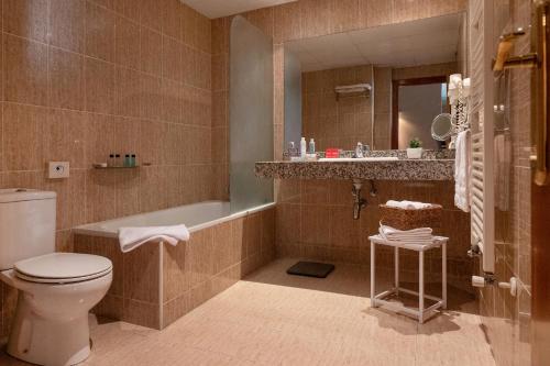 La salle de bains est pourvue de toilettes, d'une baignoire et d'un lavabo. dans l'établissement Apartaments Sant Bernat, à Canillo