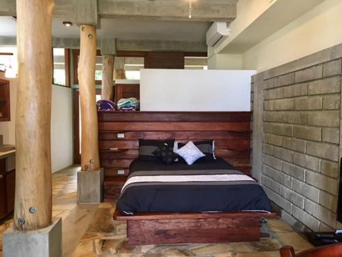 1 dormitorio con 1 cama en una pared de ladrillo en Modern Studio/Apt overlooking Pool/Ocean view, en San Juan del Sur