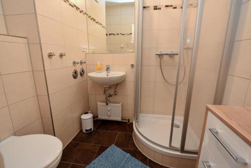 y baño con ducha, aseo y lavamanos. en Haus Jan am Strand Wohnung - 215, en Cuxhaven