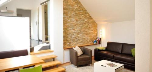 uma sala de estar com um sofá e uma parede de tijolos em Weingut Edling em Roßdorf