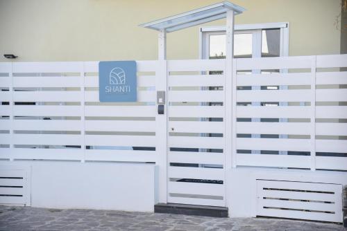 a white fence with a sign on it at Shanti Rooms & Apartments Risorgimento in Bacoli