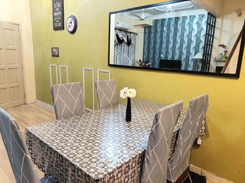 a dining room table with chairs and a mirror at E&A Homestay KLIA/ Sepang/ Nilai in Sepang