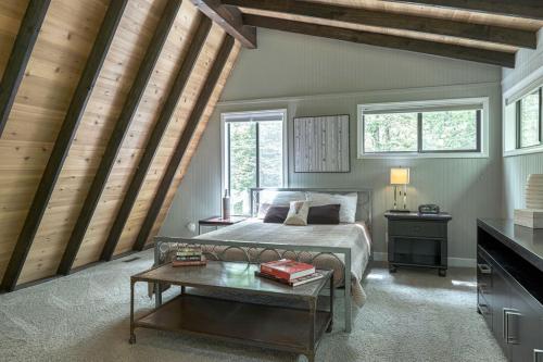 1 dormitorio con cama, mesa y ventanas en Treetop Getaway by Sarah Bernard Chalets, en Innsbrook
