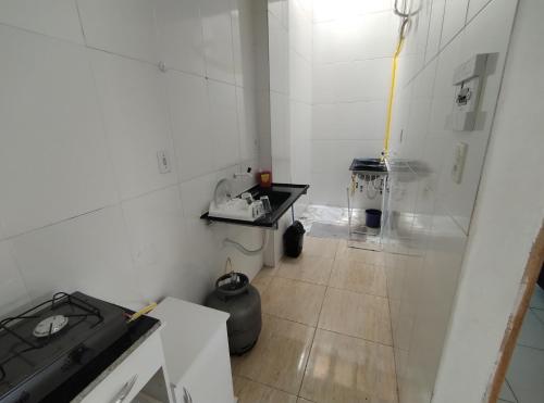 een kleine witte keuken met een fornuis en een vloer bij Kitnet em Serrinha, Bahia in Serrinha