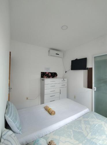 een witte slaapkamer met een bed en een koelkast bij Kitnet em Serrinha, Bahia in Serrinha
