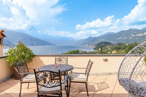 a table and chairs on a balcony with a view of the water at Villa La Perla - Bellagio in Bellagio