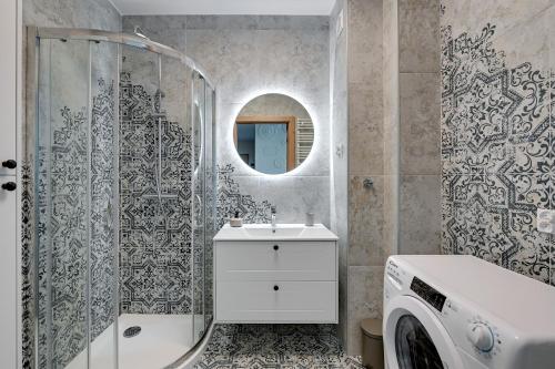 a bathroom with a sink and a washing machine at Apartament Nadmorskie Tarasy in Gdynia