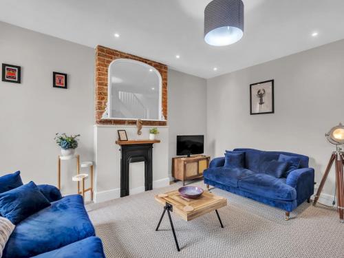 ein Wohnzimmer mit zwei blauen Sofas und einem Tisch in der Unterkunft Pass the Keys Spacious and Modern Sea Side apartment in Whitstable
