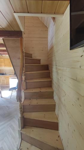 a staircase in a wooden cabin with a tv on the wall at Domek drewniany Krokus in Witów