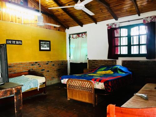 una camera con due letti e una tv di Casa estilo cabaña "Rosita" a Paso de la Patria