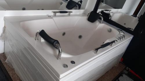 Una bañera blanca con dos armas. en Venecia Hotel Larco, en Trujillo