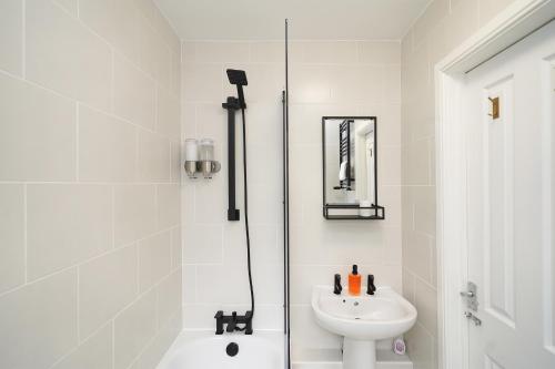 a white bathroom with a sink and a shower at Rural escape with peaks from your door in Sheffield