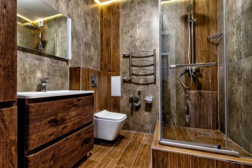 y baño con ducha, aseo y lavamanos. en Apartment Severnoye Siyaniye 37, en Astana
