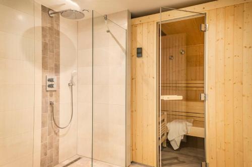 eine Dusche mit Glastür im Bad in der Unterkunft Haus Strandläufer Apartment 2 2 Küstennebel in Büsum