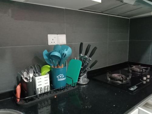 a kitchen counter with a cup filled with utensils at RatuSpaQ Home Desaru Utama Residence Apartment in Bandar Penawar