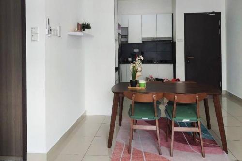 a kitchen with a wooden table and four chairs at RatuSpaQ Home Desaru Utama Residence Apartment in Bandar Penawar
