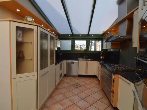 a large kitchen with a large skylight at Lavish Villa in Middelkerke with Sauna in Middelkerke