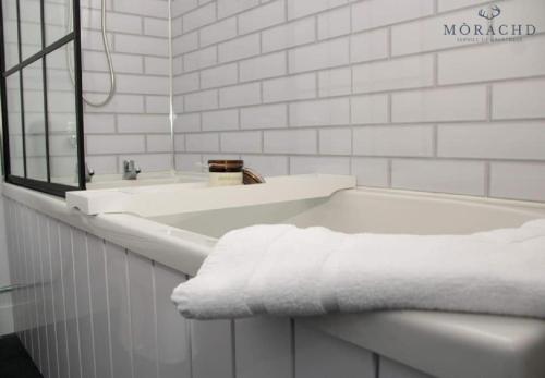 a white bathroom with a tub and a sink at Linton in Kinghorn